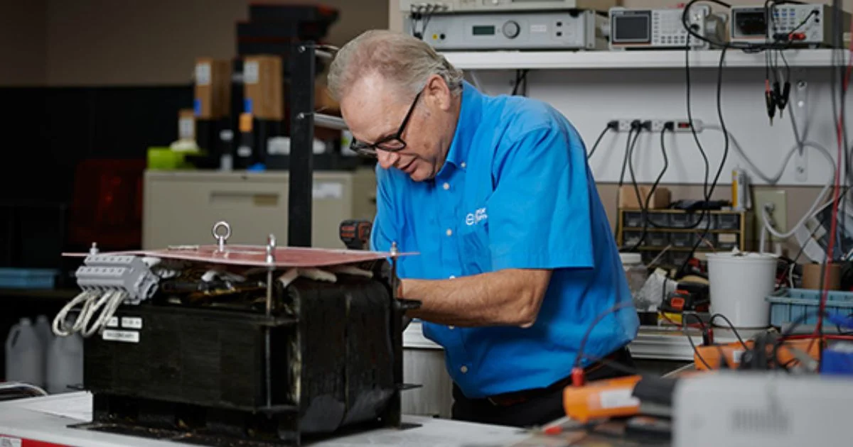 Engineer testing custom magnetic component in electronics laboratory