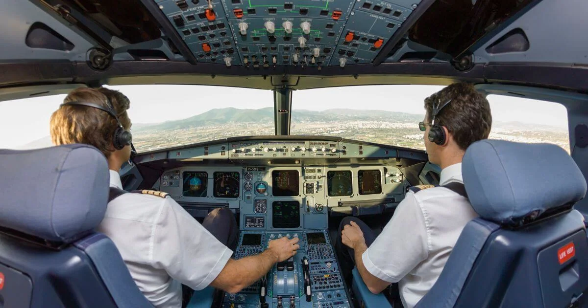 Pilots operating commercial airplane cockpit in flight